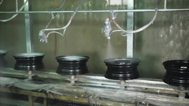 Robotic painting machines are spraying metallic paints over steel wheels. - Footage, Video
