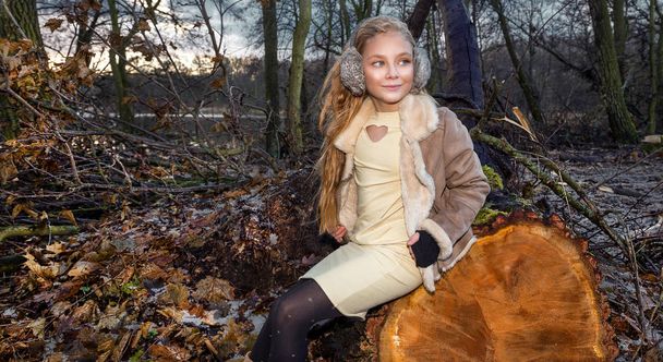 Mooi lief klein meisje gekleed in een jas van schapenvacht en boot - Foto, afbeelding