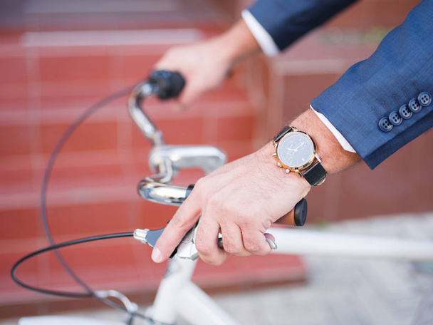 Businessman rides on his white bicycle on the street close-up clock - Fotoğraf, Görsel