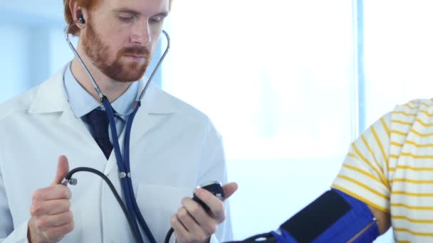 Doktor sprawdzania ciśnienia krwi pacjenta w klinice - Materiał filmowy, wideo