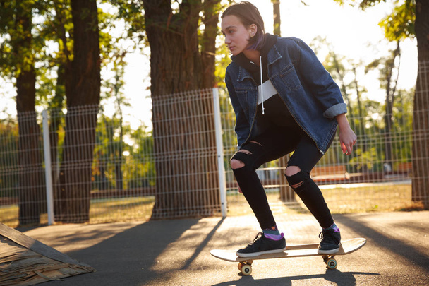 Young girl riding a skateboard. Skateboarding. Outdoors, lifestyle. - Фото, изображение