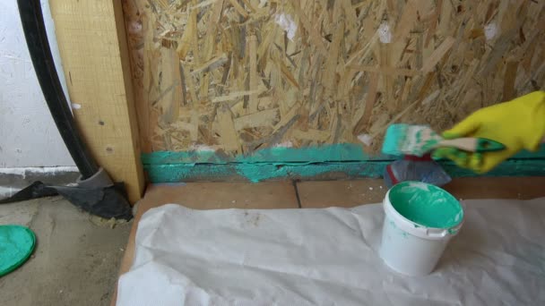 Työntekijä siveltimellä vedeneristys puinen kylpyhuone rakentaminen
  - Materiaali, video