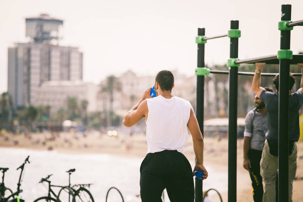 exercise in the open air in the gymnasium on the beach barceloneta on the shores of the Mediterranean Sea in Catalonia - Foto, afbeelding