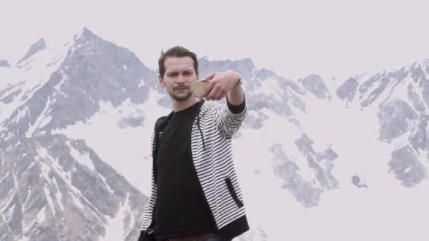 Fiatal férfi csíkos kapucnis pulcsit, így selfie a hegy látni látvány - Felvétel, videó