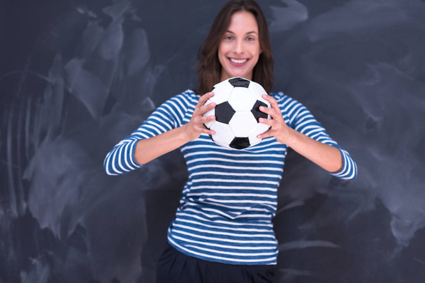 woman holding a soccer ball in front of chalk drawing board - Foto, Imagen