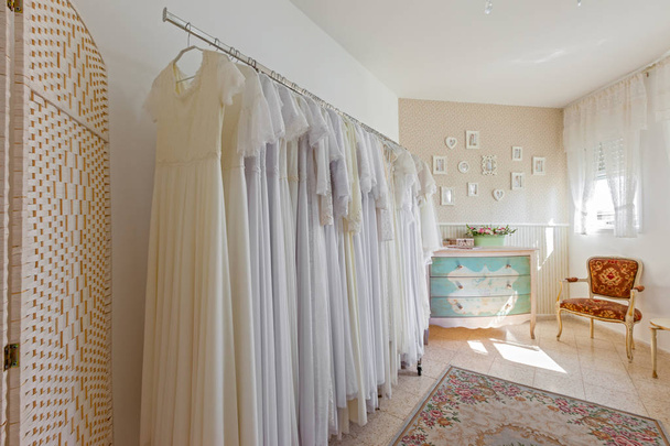 Innenraum des Brautsalons. wunderschönes Brautkleid auf einem Kleiderbügel. - Foto, Bild