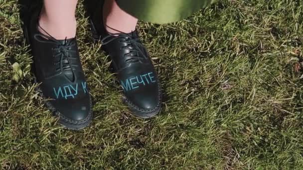 Κορίτσια πόδια σε μαύρο δέρμα μπότες ιππασίας με ρωσικό κείμενο «πηγαίνοντας προς το όνειρο" - Πλάνα, βίντεο
