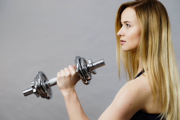 Fit woman lifting dumbbells weights - 写真・画像