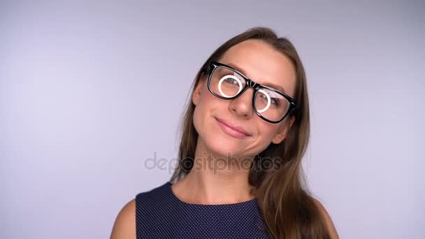 Giovane donna d'affari in occhiali guardando macchina fotografica felice. L'abbagliamento rotondo si riflette nei bicchieri
 - Filmati, video