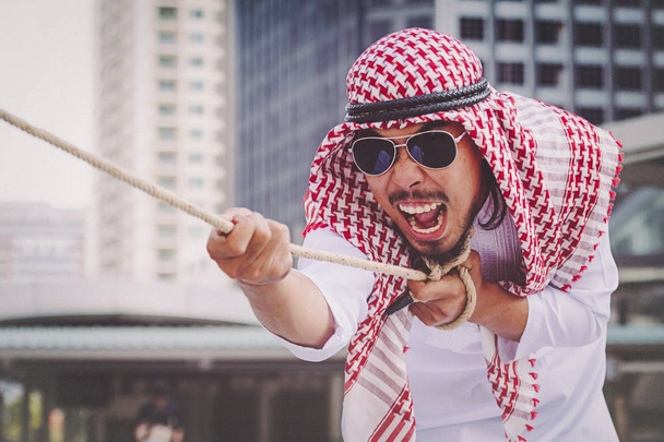 Emiraty biznesmen ciągnięcia liny - Zdjęcie, obraz