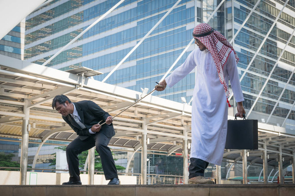 Empresários árabes e homem de negócios jogando rebocador de guerra no fundo da cidade
 - Foto, Imagem
