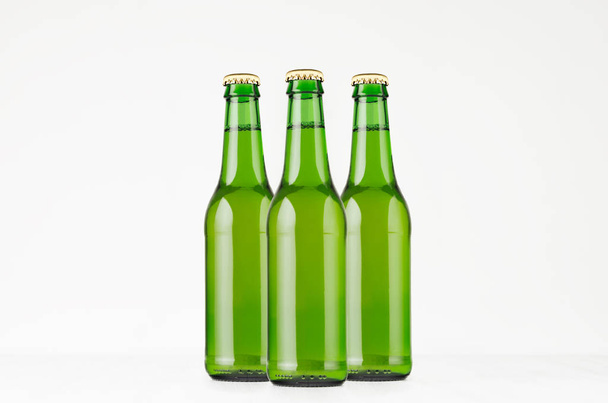 Group green longneck beer bottles 330ml, mock up. Template for advertising, design, branding identity on white wood table. - Photo, Image