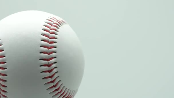 白い背景と赤いステッチ野球で孤立した野球を回転させます。コピー スペース. - 映像、動画
