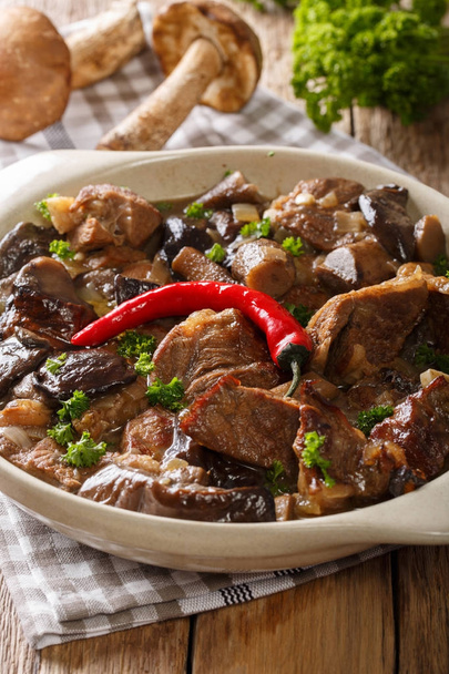 Deliciosa carne bovina com cogumelos silvestres, pimenta e molho perto
 - Foto, Imagem