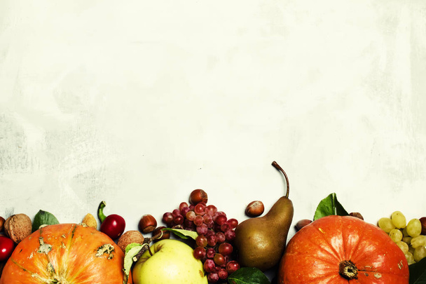 Food background with pumpkins, vegetables, fruits and nuts  - Foto, afbeelding