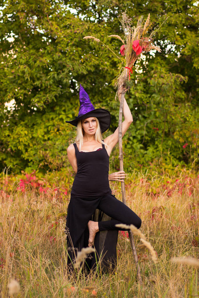 Gioiosa femmina in costume da strega che pratica yoga
 - Foto, immagini