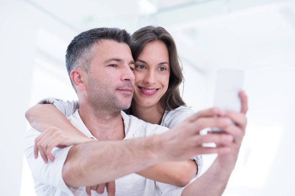 happy couple using mobile phone at home - Foto, Imagen