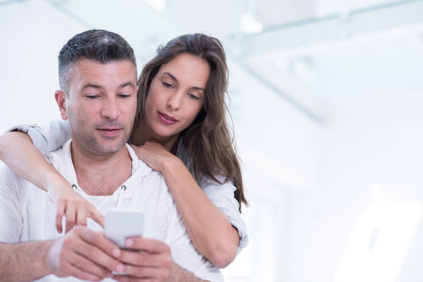 happy couple using mobile phone at home - Foto, Imagem