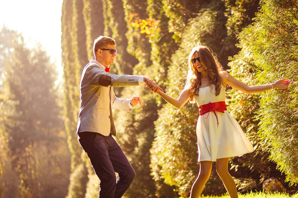 Happy couple having fun, dancing and playing in the autumn park - Valokuva, kuva