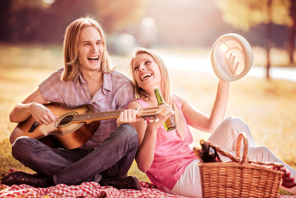 Пара на пикнике, играющая на гитаре
 - Фото, изображение