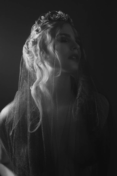 Queen of darkness in black fantasy costume on dark gothic background. High fashion beauty model with dark makeup. - Fotó, kép