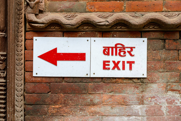 Sinal de saída em nepali e inglês
 - Foto, Imagem