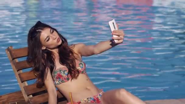 Young sexy woman make selfie near swimming pool - Video