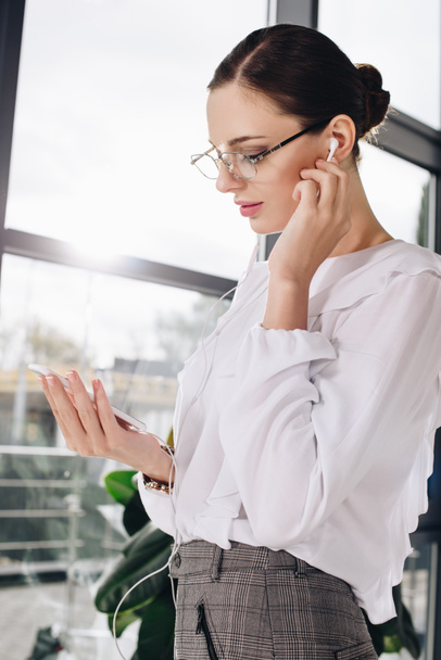бізнес-леді слухає музику в навушниках
 - Фото, зображення