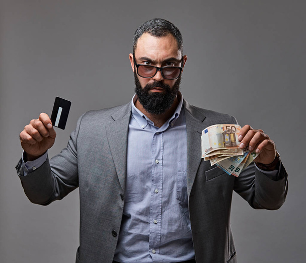 Bebaarde man houdt geld - Foto, afbeelding