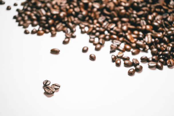 coffee grains are beautifully scattered on a white table - Фото, изображение