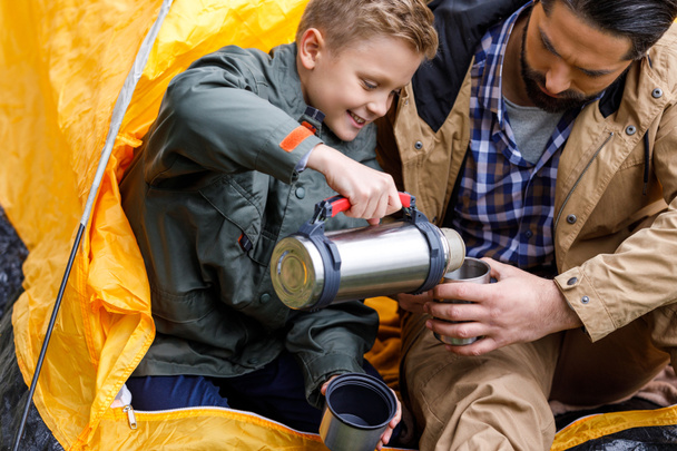 son with thermos in camping - Photo, Image