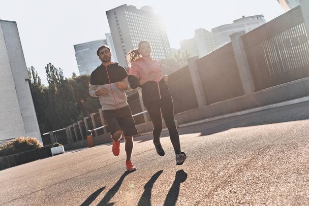 sportive couple running in city - 写真・画像