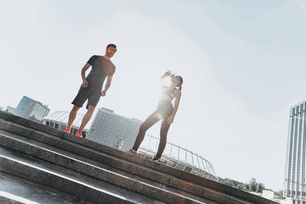 sportive man and woman standing on stairs - Zdjęcie, obraz