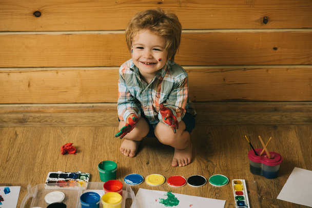 Boy painter painting on wooden floor - Photo, Image