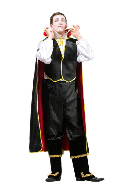 halloween, costume party, entertainment concept. handsome womanizer is dressed up as count dracula in silk costume with snowy white shirt and black pants with jacket. isolated figure - Φωτογραφία, εικόνα