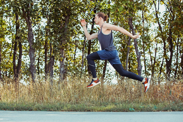 Running sport. Man runner sprinting outdoor in scenic nature. Fit muscular male athlete training trail running for marathon run. - Fotoğraf, Görsel