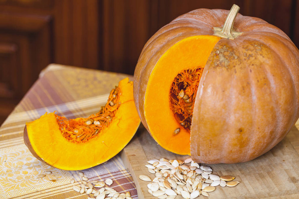 beautiful piece of ripe pumpkin is next to round pumpkin - Photo, Image