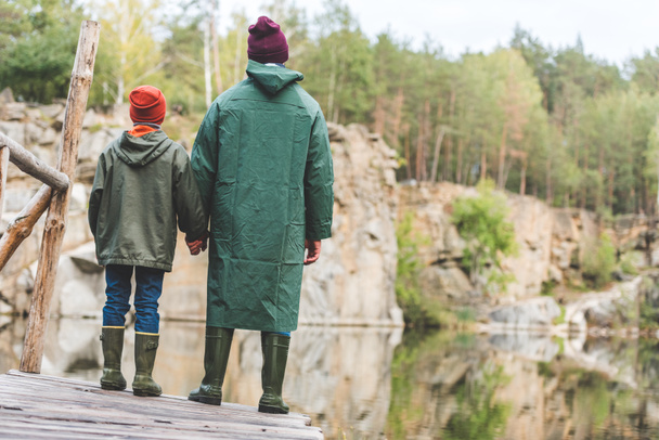 father and son standing on bridge in forest - Foto, imagen