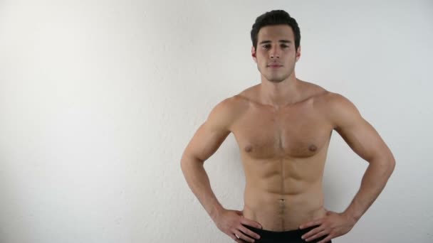 Knappe shirtloze atletische jonge man op wit - Video