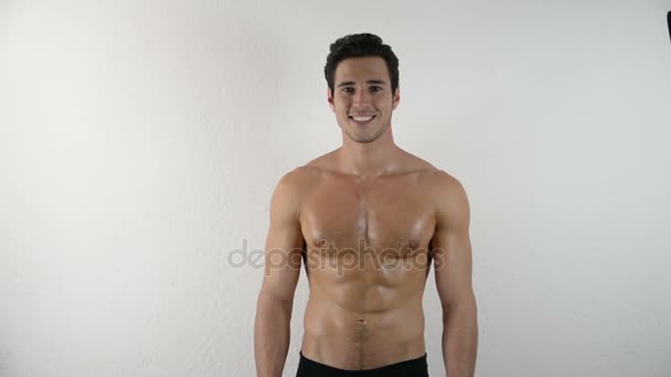 Красивый спортивный молодой человек без рубашки на белом - Кадры, видео