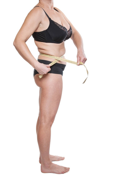 Woman winding round with tape-measure - Φωτογραφία, εικόνα