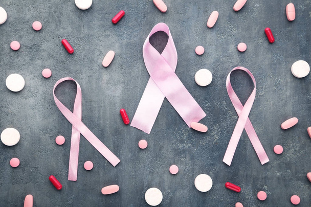 Pink ribbons with tablets and capsules  - Photo, Image