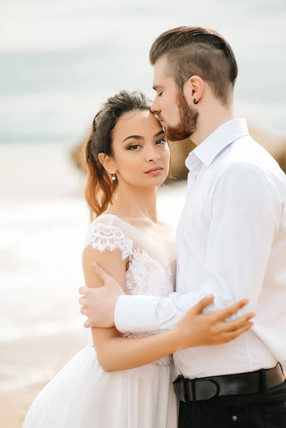 砂浜で花嫁と若いカップルの新郎 - 写真・画像