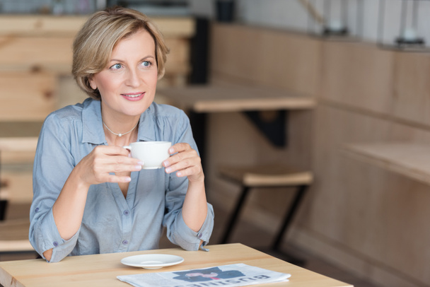 Женщина пьет кофе в кафе
 - Фото, изображение