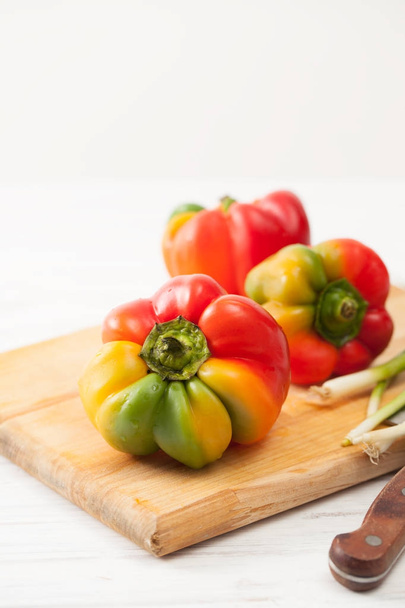 Sweet ripe peppers on the kitchen Board on a white - Photo, image