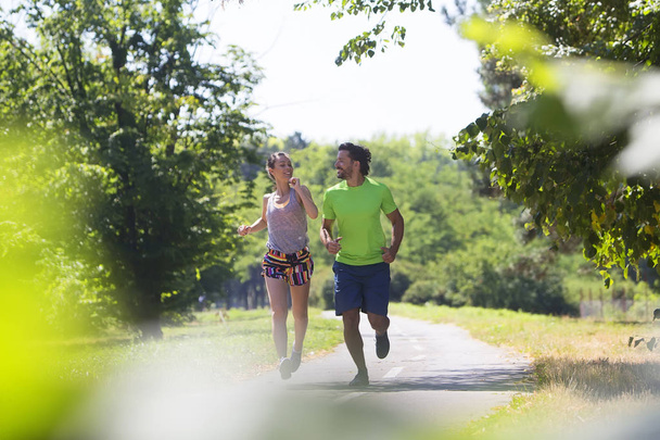 Sportive couple running in park - Фото, зображення