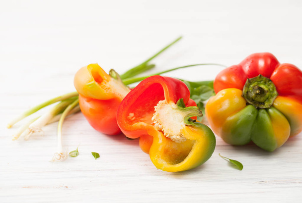 Half cut raw sweet colorful peppers on white - Foto, Imagem