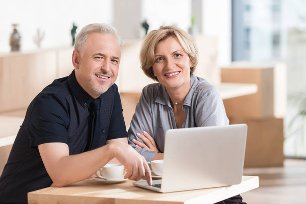 casal sentado à mesa com laptop
 - Foto, Imagem