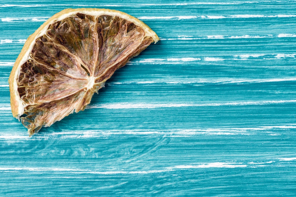 Сушеный лимон на синем деревянном фоне
 - Фото, изображение