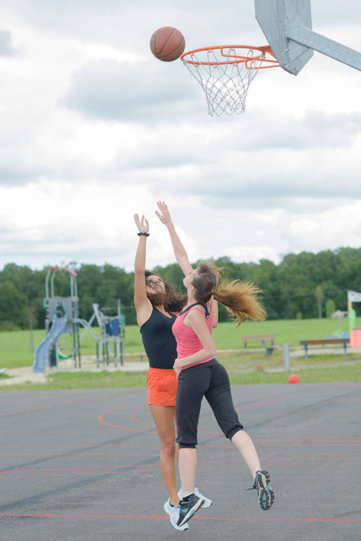 beautiful young women playing basketball outdoors - Fotoğraf, Görsel